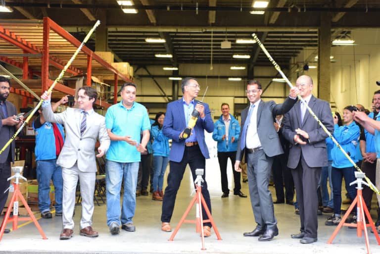 Photo of Minister Virk “cutting the ribbon” (or in this case, PVC pipe) at Saltworks’ factory in Richmond, BC