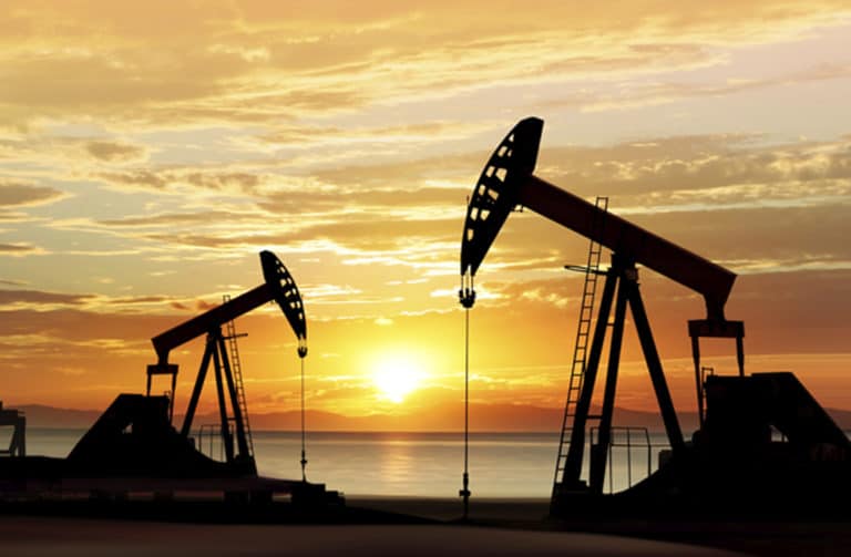 Photo of a silhouette of working oil pumps with a sunset background