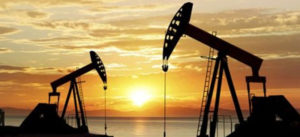 Photo of oil wells with sunset behind