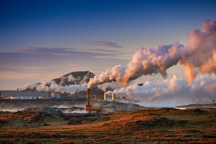 Photo of steam billowing from a geothermal system
