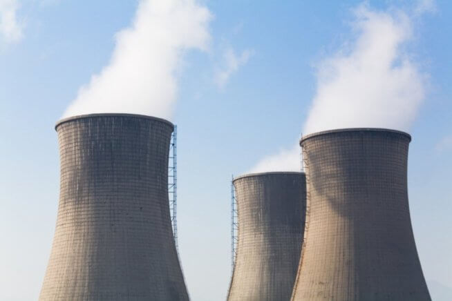 A photo of cooling towers producing steam