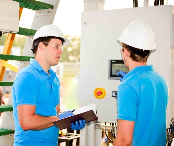 A photo of Saltworks engineers standing and talking in a wastewater treatment plant