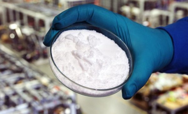 Photo of Lithium carbonate prepared in Saltworks' Lithium Test Centre with the factory floor behind.